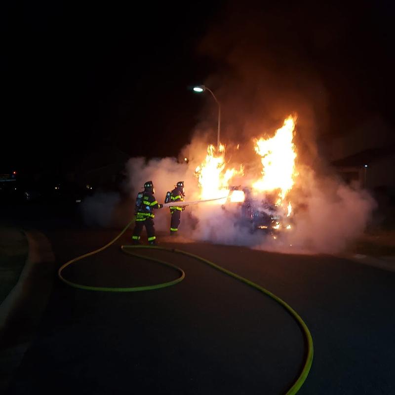 Firefighters Centrone and Sierra extinguishing a vehicle fire.