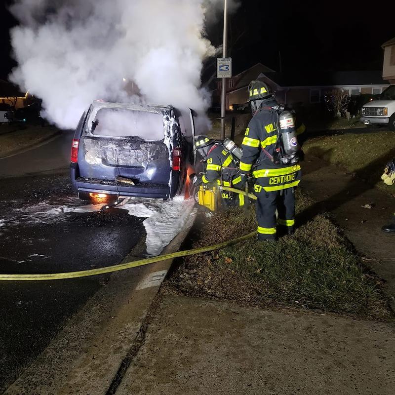 Firefighters Centrone and Sierra using foam to extinguish a vehicle fire.