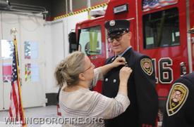 FF James Anderson's wife, Lisa, pins on his retirement badge.